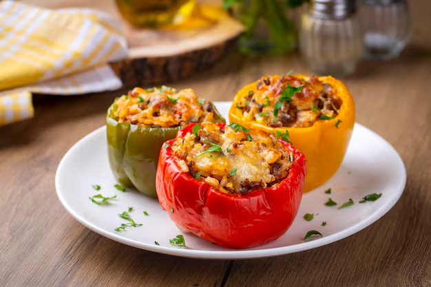 Stuffed bell peppers with rice and black beans in a baking dish.